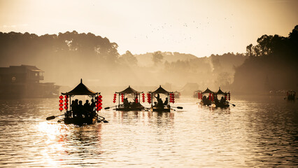 silhouette sailing chinese boat on lake in Ban Rak Thai village at sunrise