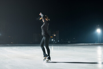 Fototapeta na wymiar Beautiful young woman ice skating