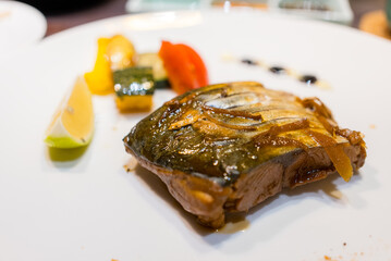 Slice of grilled fish on the white plate