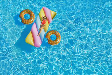 Photo - Illustration of inflatable rounds and pool swimming mattress forming a discount symbol....