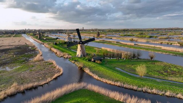 Aerial View to the wooden windmills at sunset in the Netherlands village of Kinderdijk. The beautiful Dutch canals are filled with water. Unesco World Heritage. Reflection. Holland, Europe from above