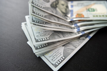 100 american hundred-dollar bills in black  desk