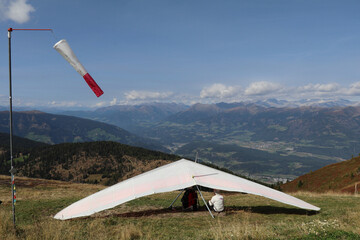hang glider pilot and his coach sitting underneath the triangle control frame of a hang glider...
