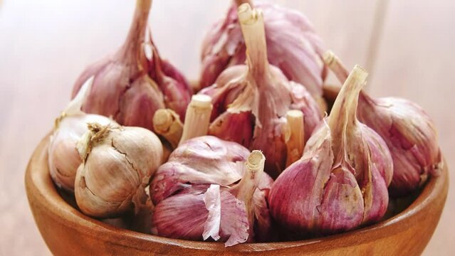 Gyration old garlic on a bowl on a wooden table background.