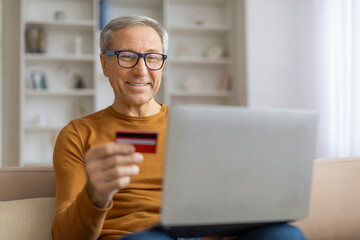Senior shopping online with laptop and card