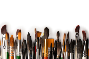 Mix of paint brushes in a row isolated on a white background.  Top view.