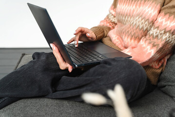 Unrecognizable female hands typing on laptop keyboard.
