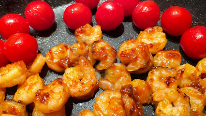 Fried shrimp in sauce with cherry tomatoes, delicious healthy food, seafood with vegetables is an excellent combination