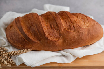 White bread on a wooden board on a gray table.