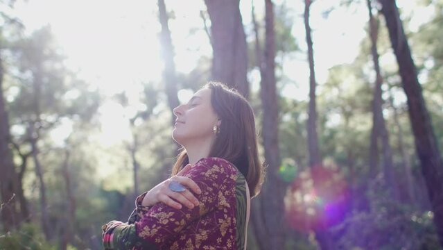 girl alone with nature. concept of calm and tranquility. young and beautiful girl among natural landscapes. A young and beautiful girl dances and sings in the forest among the trees.