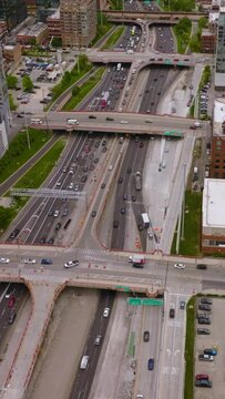 Hundreds of cars on the roads and parking lots of amazing Chicago. Wide multi-lane road crossed by bridges of skyways. Top view. Vertical video