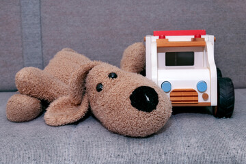 Toys on a bench in a waiting area, stuffed toy dog and wooden toy ambulance.
