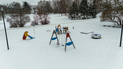 Drone photography of children playground covered by snow during winter day