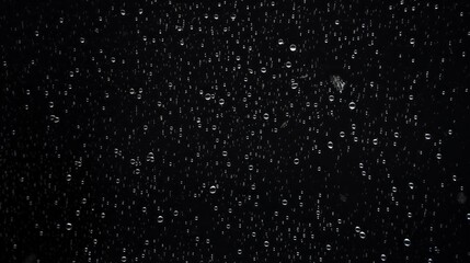 A black and white photo of raindrops on a window