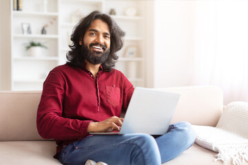 Relaxed man with laptop sitting on couch