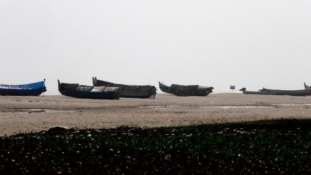 Fishing boats moored on the beach at Adimalathura, Thiruvananthapuram, Kerala, India on a hot day
