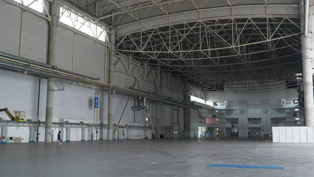 Large empty storehouse, huge premise. Worker walks through huge warehouse