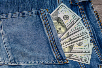 One hundred dollar banknote money in pocket jeans pants background texture. 100 dollar bill close...