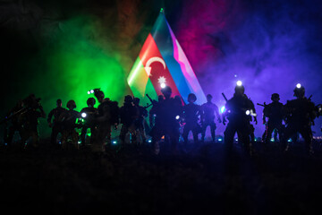Azeri army concept. Silhouette of armed soldiers against Azerbaijani flag. Creative artwork...