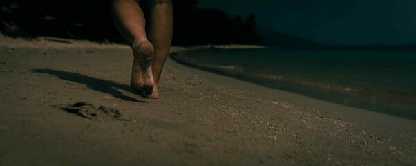 person walking on the dark beach