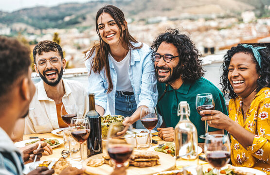 Happy friends having barbecue dinner party at home balcony  - Young people enjoying lunch break at restaurant terrace