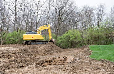 Backhoe Excavating and Reshaping Landscape