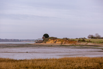 View of Wrabness beach from across the bay, Image shows the small beach at low tide showing the...