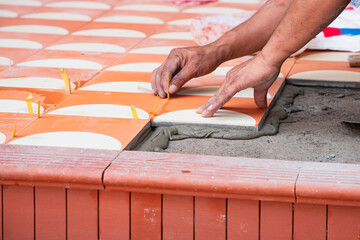 industrial ceramic  builder worker installing floor tile at repair renovation work - Handyman...