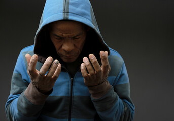 man praying to god with hands together on grey background with people stock image stock photo	