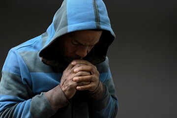 man praying to god with hands together on grey background with people stock image stock photo	