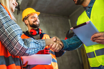 Contractor. construction worker team hands shaking after plan project contract  at construction...