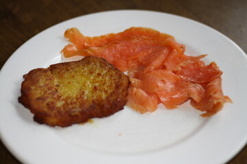 potato pancakes, grated biscuits with salmon, served on a white plate,