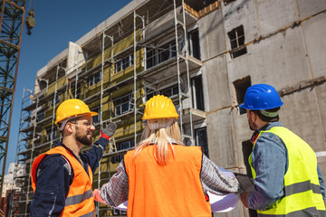 Construction team planning a building blueprint project on site with collaboration for architect innovation. Architecture, design and engineers with teamwork for successful