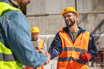 Contractor. construction worker team hands shaking after plan project contract  at construction...