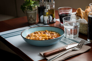 Hearty Breakfast: Pork's Head and Trotters with Tripe and Beans Stew - Traditional Catalan Cuisine in a Rustic Restaurant Ambiance.