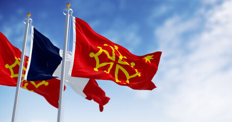Flags of Occitanie region and France waving in the wind on a clear day