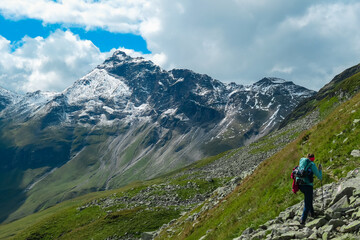 Fototapeta premium Hiker woman on extreme alpine terrain with scenic view of majestic mountain peak Vorder Geisslkopf, High Tauern National Park, Carinthia, Austria. Idyllic hiking trail remote Austrian Alps. Wanderlust