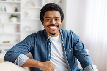 Smiling Black Man Sitting On Couch in Living Room