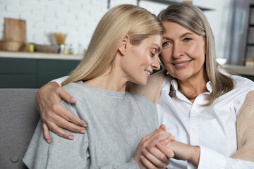 Obraz na płótnie Canvas Mature woman with her adult daughter enjoying warm communication