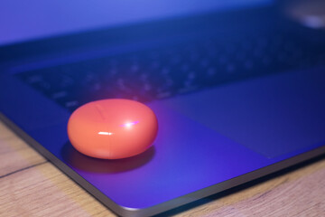 Box with Orange Wireless Bluetooth Earphones lie on the laptop. Modern  Stereo Headphones, Sports...