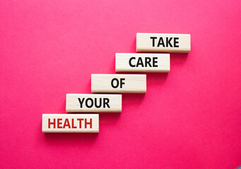 Health symbol. Wooden blocks with words Take Care of your Health. Beautiful red background. Health concept. Copy space.