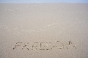 word freedom written on the sand