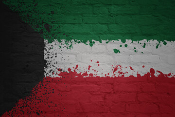 colorful painted national flag of kuwait on a massive old brick wall