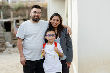 Portrait of Hispanic family - Latino parents with their son who goes to school with his backpack -...