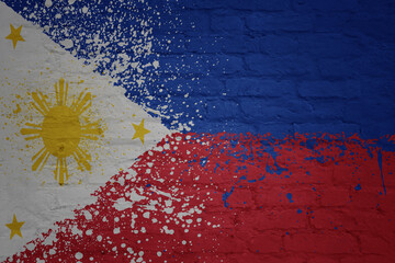 colorful painted national flag of philippines on a massive old brick wall