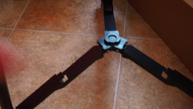 Assembling a tripod or tripod for a refractor telescope, installing a stage for lenses and spare parts. Hands of a master - an astro-lover.