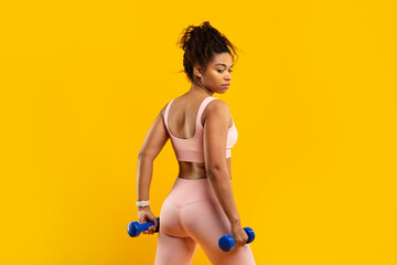 African american woman lifting dumbbells with confidence