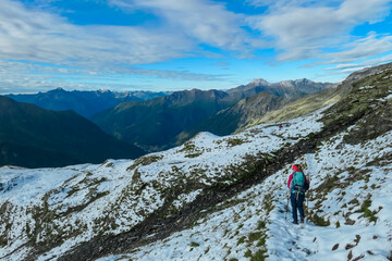 Hiker woman on alpine meadow with panoramic view of majestic mount Polinik in High Tauern National Park, Carinthia, Austria. Idyllic hiking trail in Austrian Alps. Wanderlust paradise Mallnitz