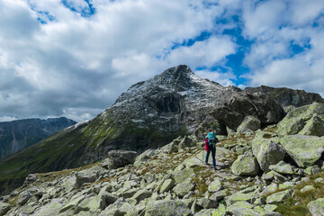 Hiker woman on alpine meadow with panoramic view of majestic mount Rameter Spitz in High Tauern...