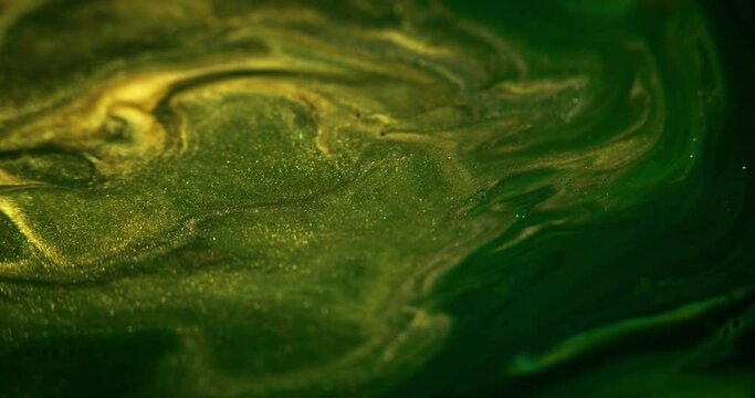 Ink flow. Sparkling paint wave. Wet glitter texture. Blur green yellow golden color shimmering dust sequin particles pigment emulsion blend motion abstract art background.